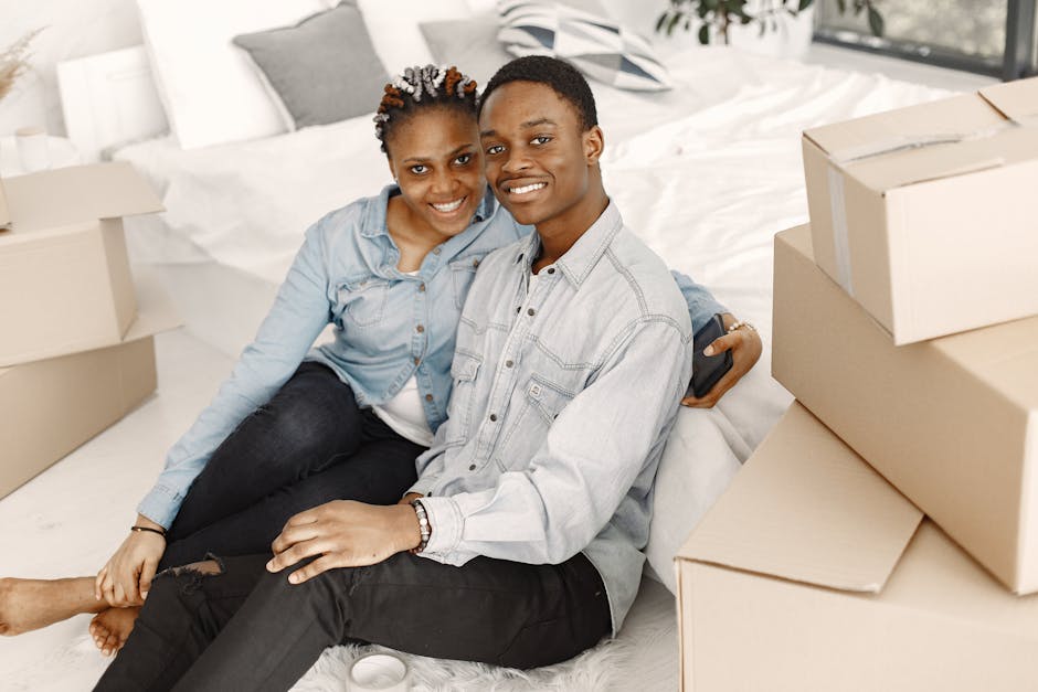Cheerful couple sitting among boxes, enjoying their new home together.