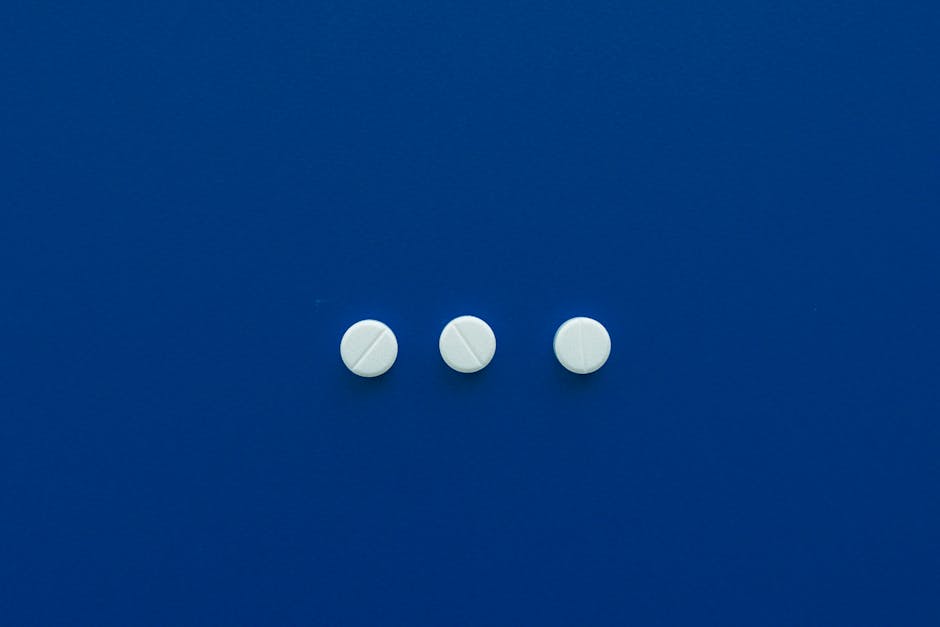 Three white pills arranged on a deep blue background for a minimalist look.
