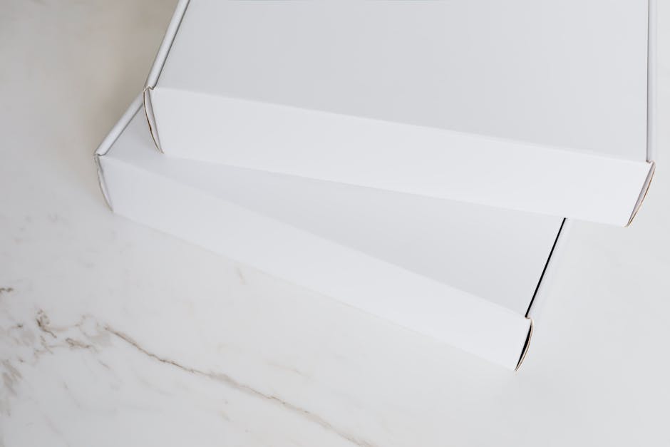 Two white cardboard boxes neatly stacked on a marble surface, ideal for online retail imagery.