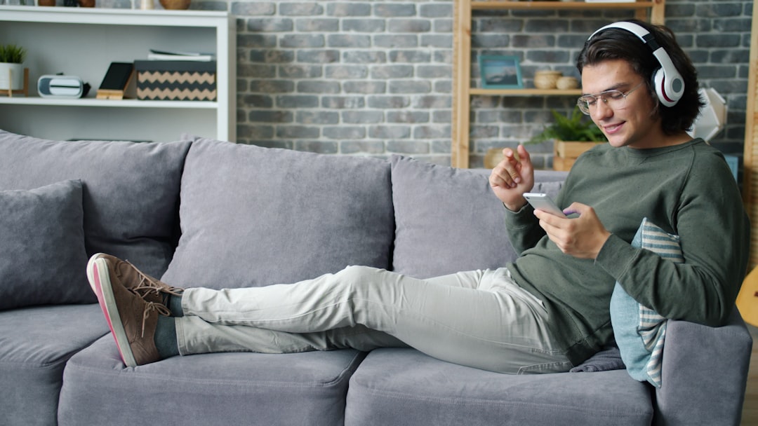 Young man with headphones listening to music on phone.