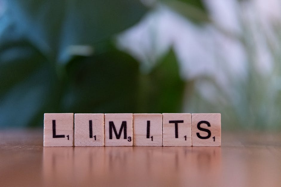 Wooden letter tiles forming the word 'LIMITS' on a wooden table.