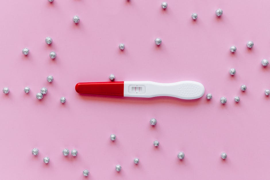 Positive pregnancy test with double lines on a pink background with silver decorations.