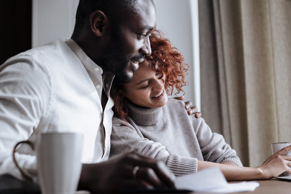 Smiling couple shares a warm moment over coffee in a cozy home setting.