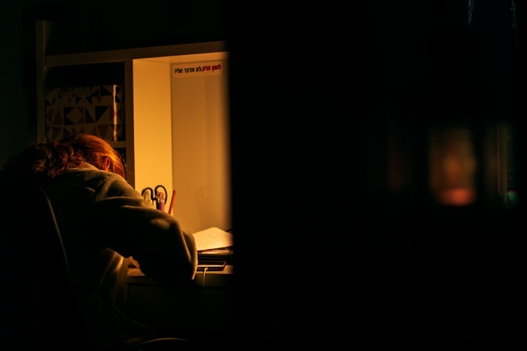 a woman sitting at a desk in the dark