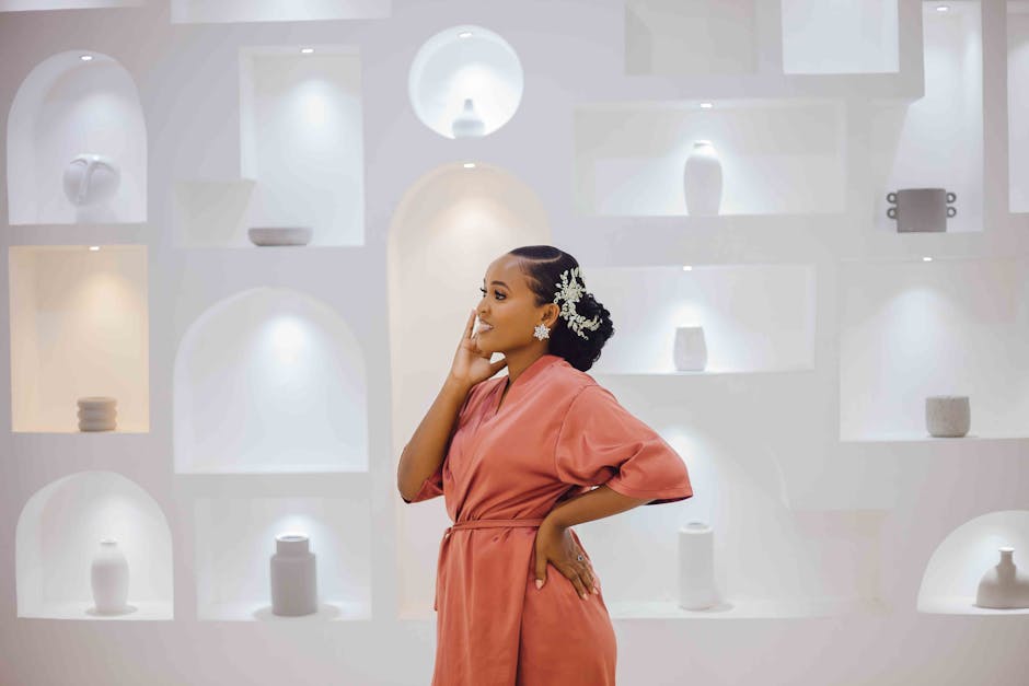 A young woman poses stylishly in a modern, well-lit interior space.