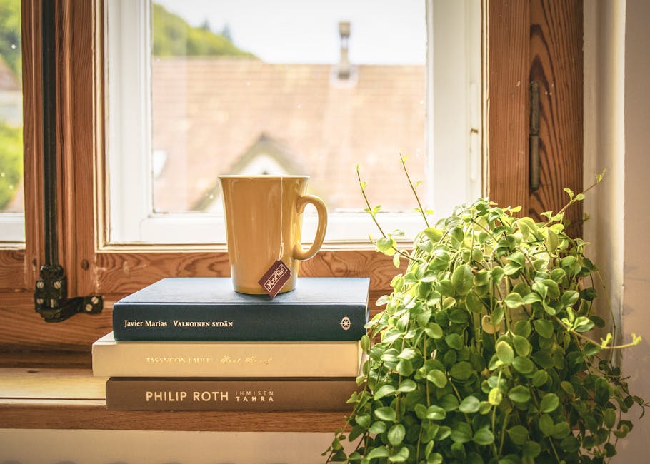A warm scene featuring a mug and books by a sunny window, perfect for relaxation and reading.